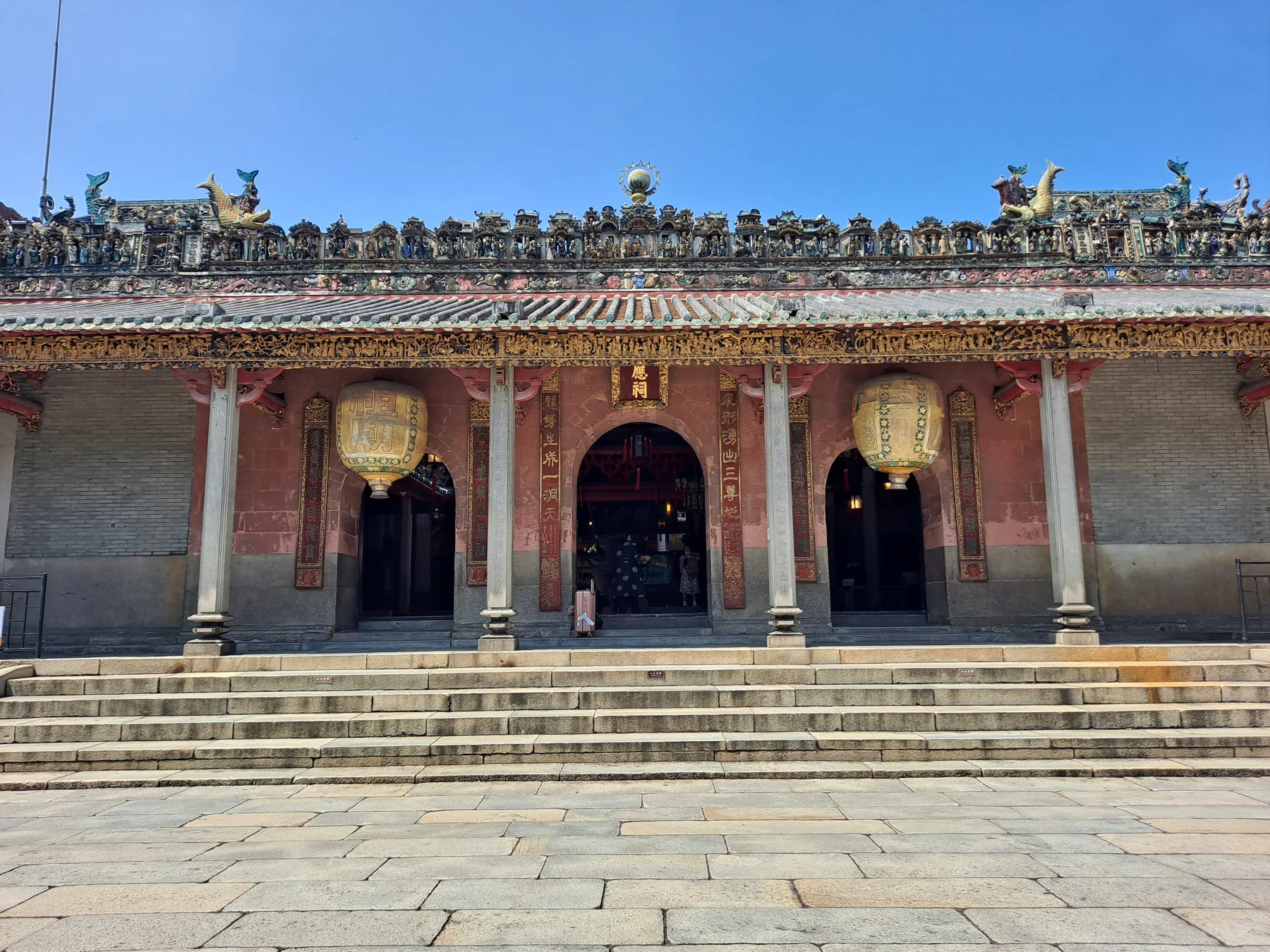 A frontal view of a historic hall and roof decoration inside Foshan Ancestral Temple