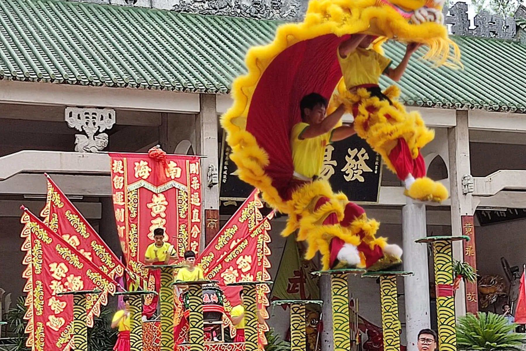 Lion-dance performer captured mid-jump above high poles at the Wong Fei-hung school
