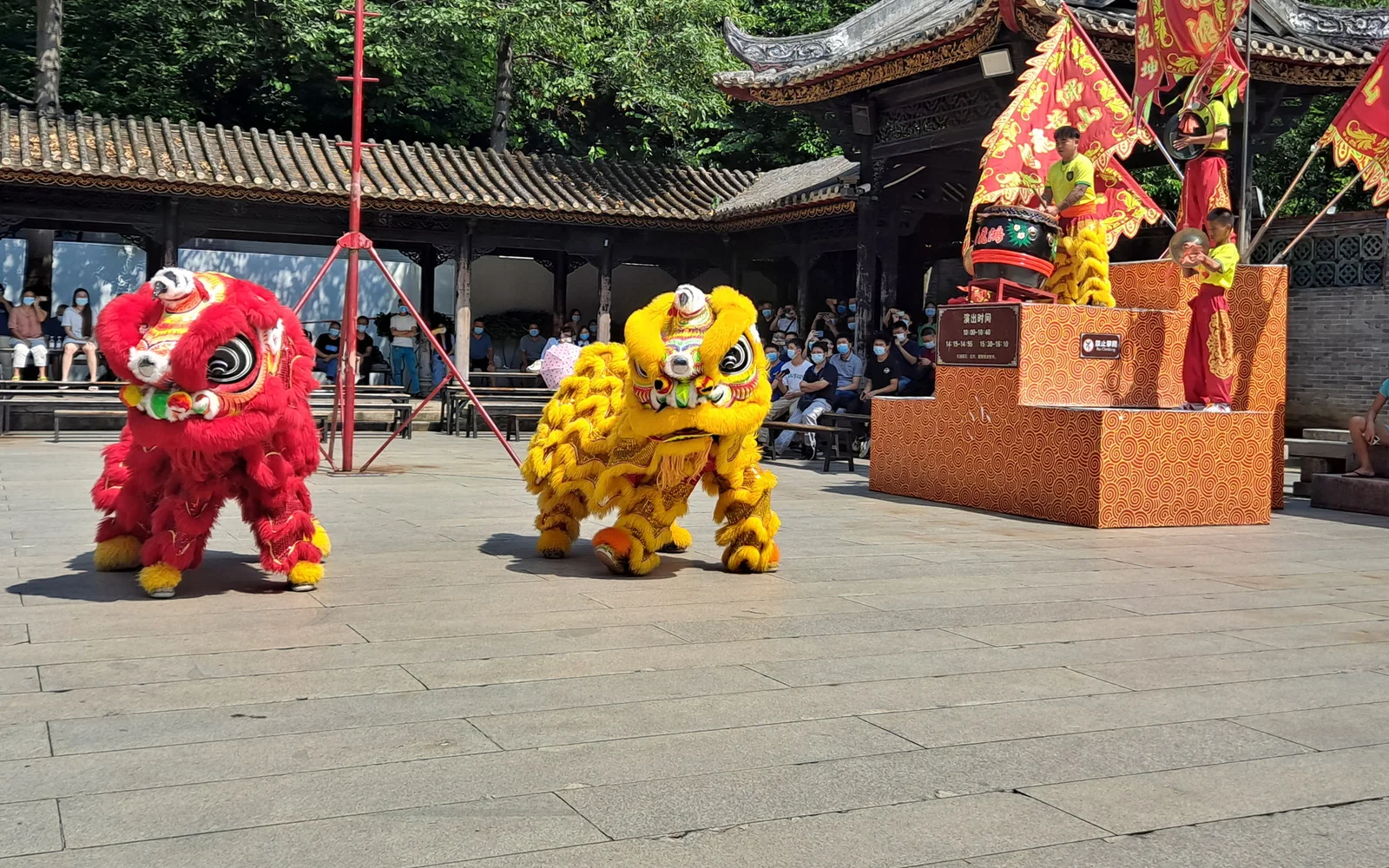 Two lions moving in front of percussion musicians at the Wong Fei-hung Memorial Hall