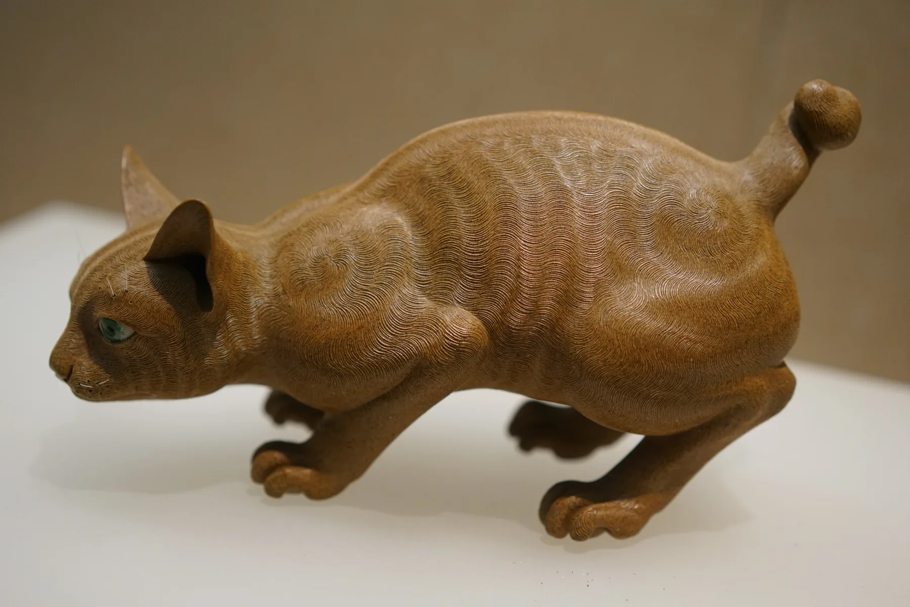 A finished Shiwan ware cat showing sculpted form and glazed surface